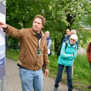 a man pointing at a poster on a wall.