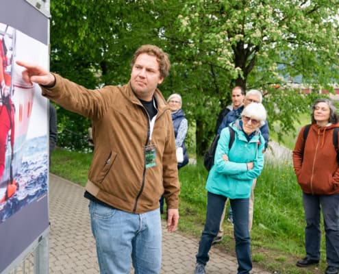 a man pointing at a poster on a wall.